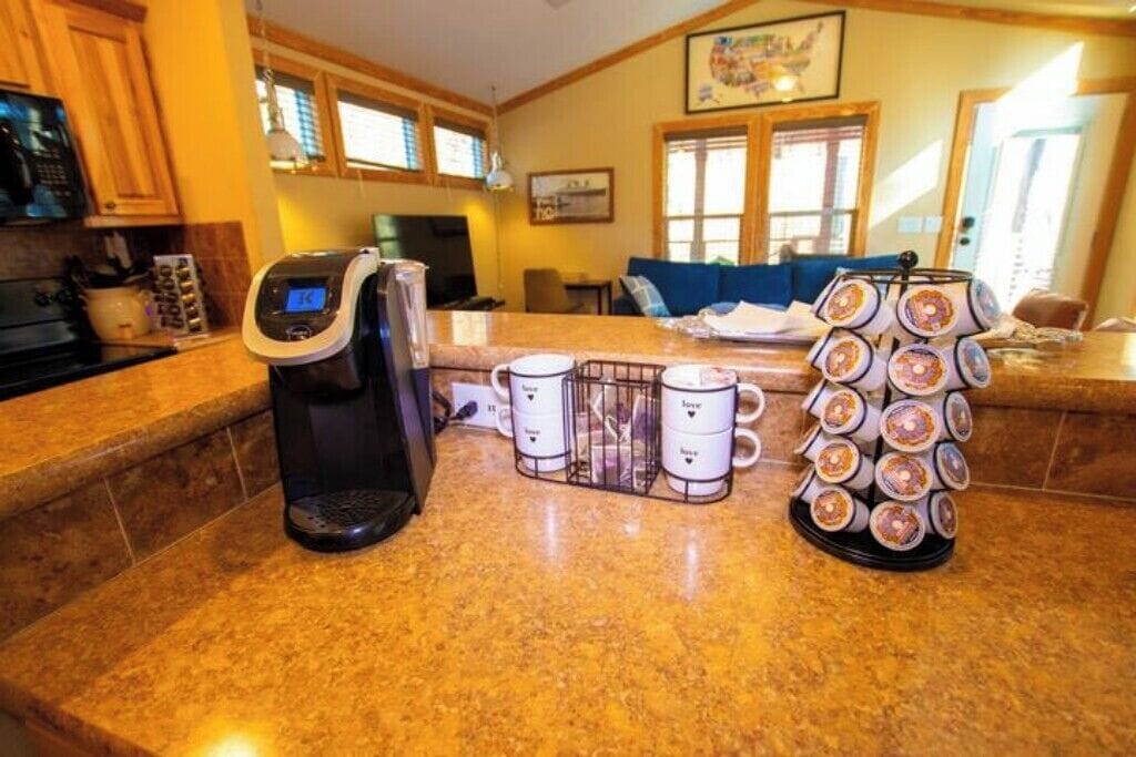 Une cuisine équipée d’une machine à café, d’un présentoir à tasses et d’un présentoir à beignets.