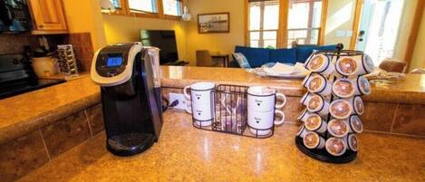 Une cuisine équipée d’une machine à café, d’un présentoir à tasses et d’un présentoir à beignets.