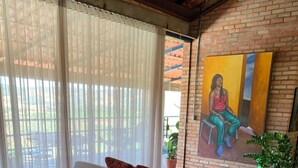 A living room with a beige sectional sofa, a wooden coffee table, and a painting on the wall.