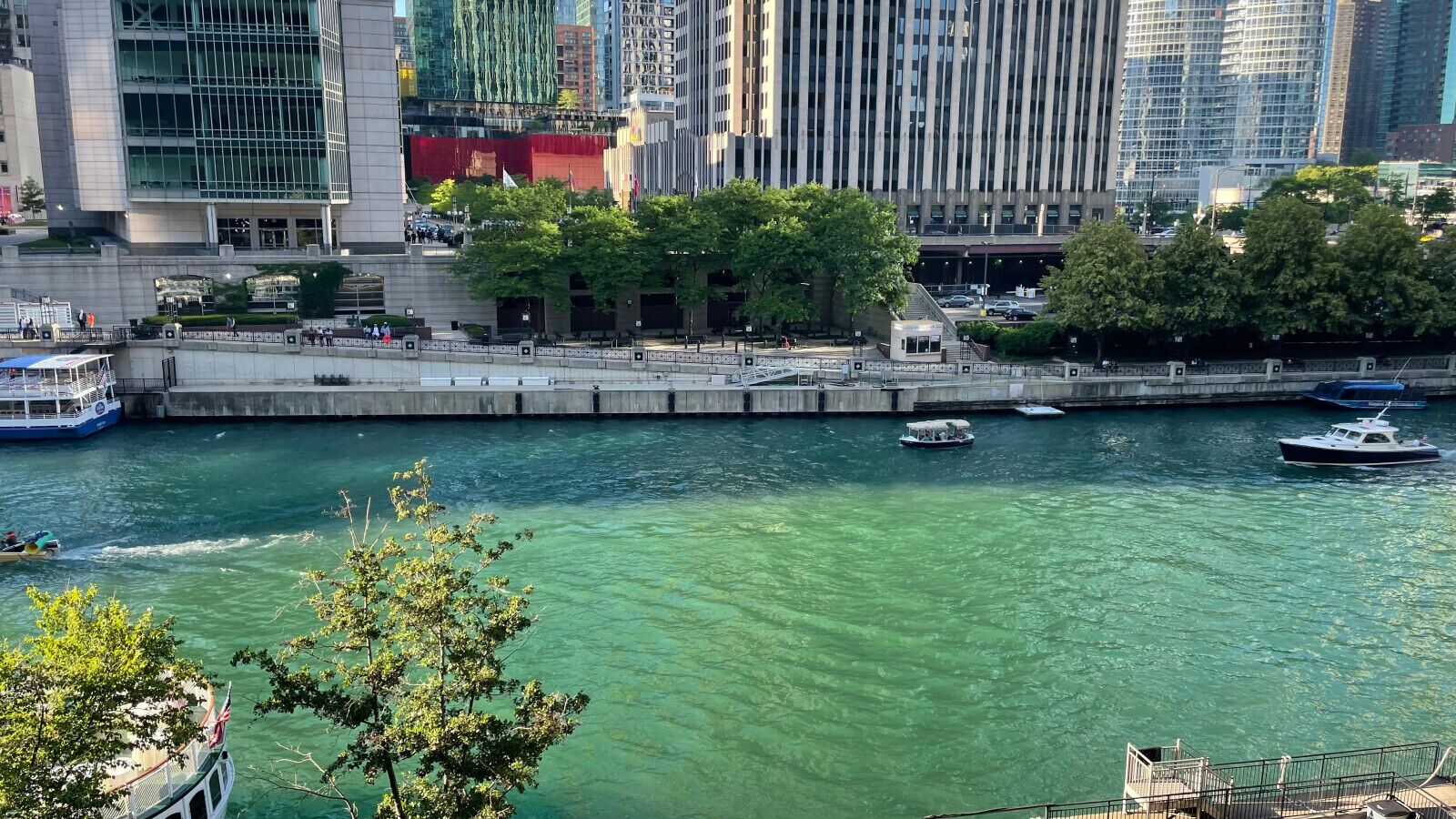 Vista al agua con río, barcos y edificios modernos al fondo.
