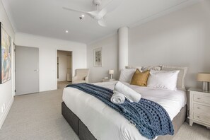 A modern hotel room with a large bed, a ceiling fan, and a view of the hallway. - Waterfront Escape, Princes Wharf with Carpark (Auckland)