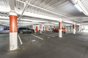 An underground parking garage with white pillars and a black car parked in a designated space. - Waterfront Escape, Princes Wharf with Carpark (Auckland)