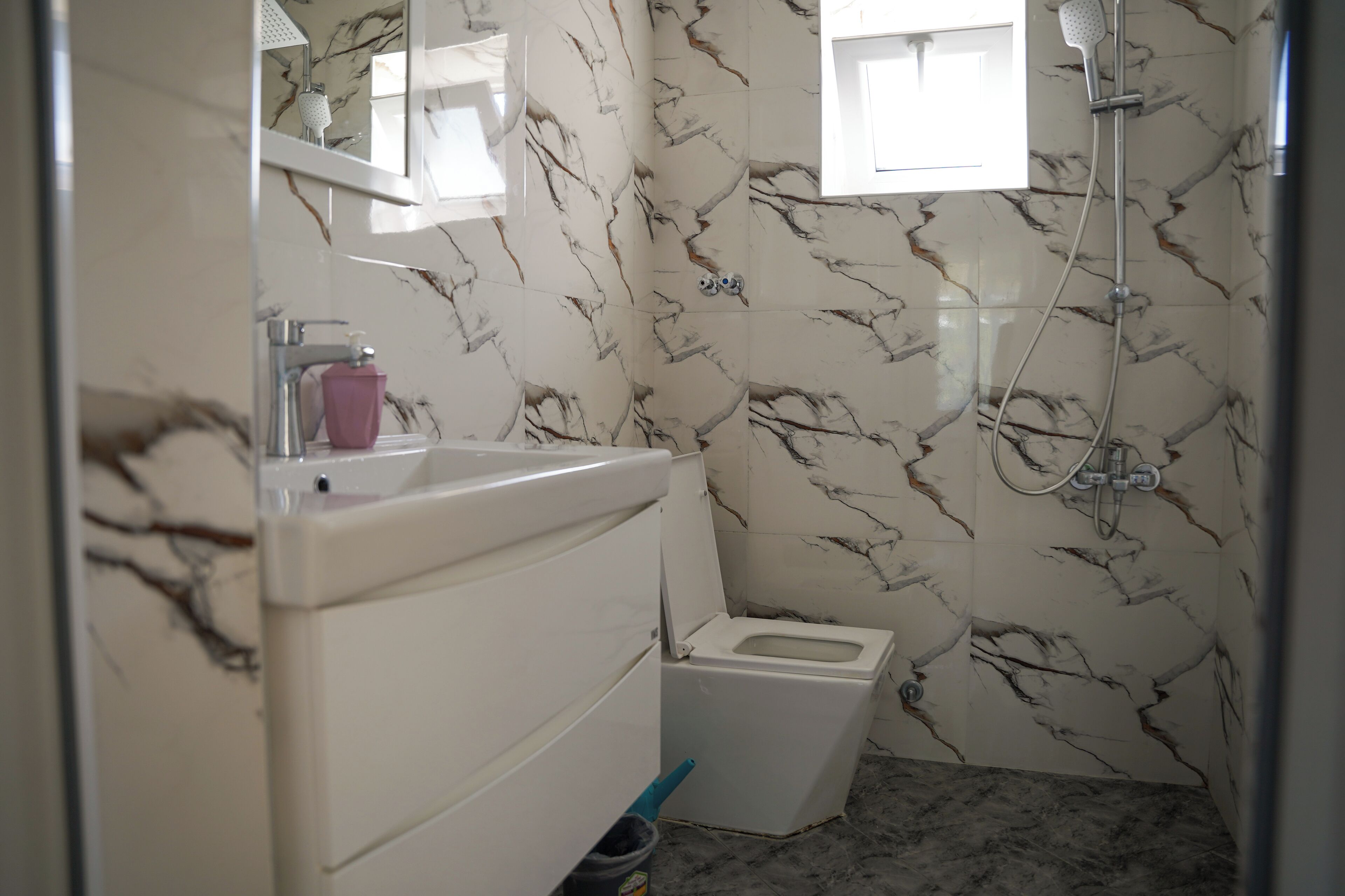 Een haardroger, handdoeken, zeep, toiletpapier