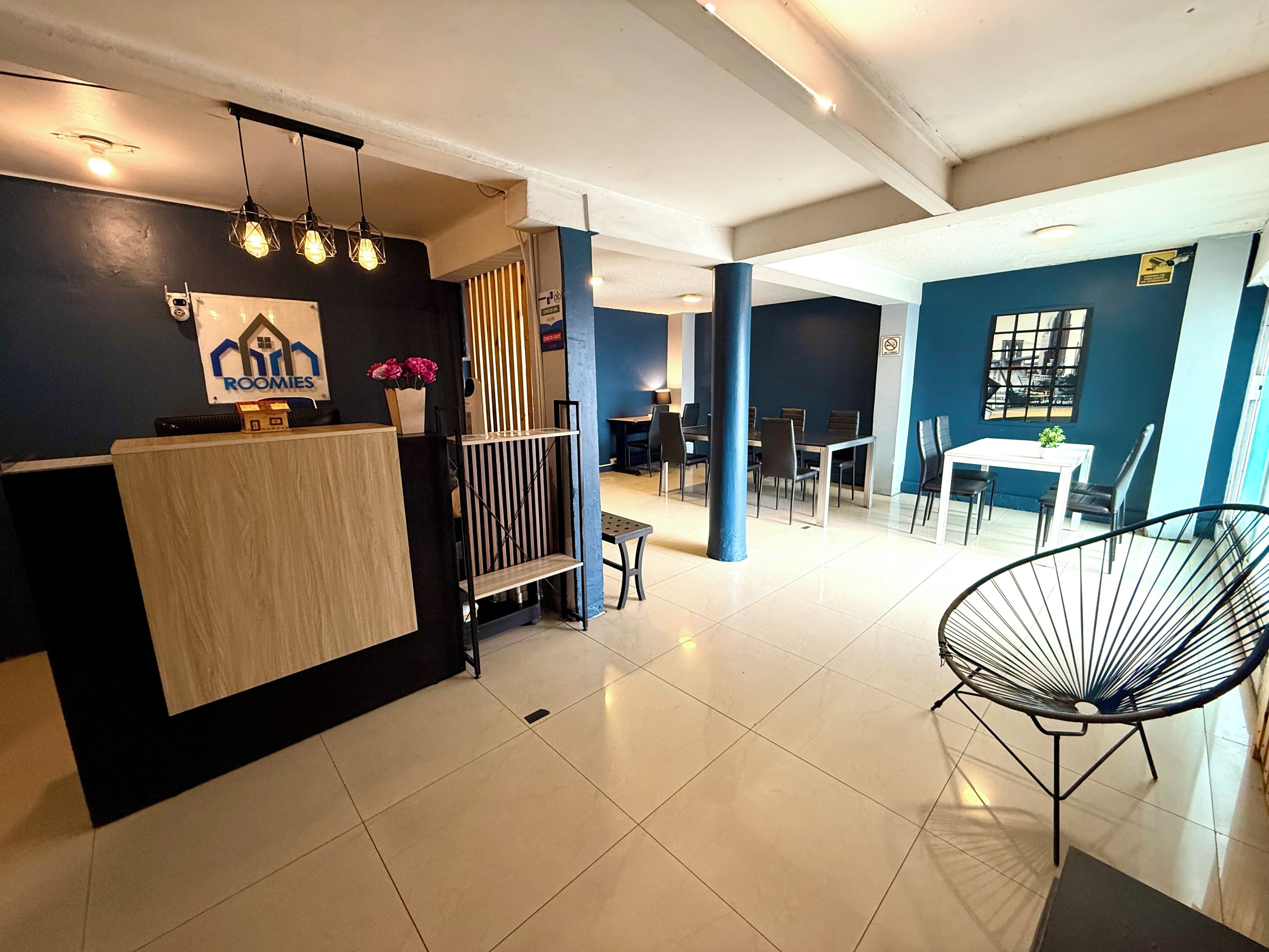 Un interior moderno con un mostrador de recepción, zona de estar y comedor.