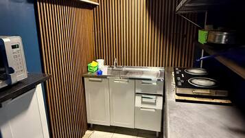 Una cocina compacta con horno empotrado, microondas y cocina a gas.