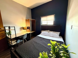 A compact bedroom with a bed, a desk, and a chair. There is a window providing natural light. - RHM Spaces - Santa Maria (Mexico City)