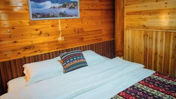 Um quarto de cabana de madeira com uma cama, um quadro na parede e um cobertor estampado.