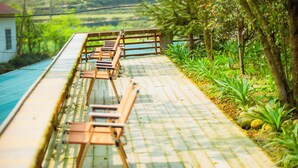 A long wooden bench along a paved pathway with a view of a green landscape. - SaPa Village Retreat - Dine & Coffee (Sa Pa)