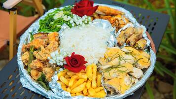 A large round table with a variety of foods including fried items, rice, and garnishes.