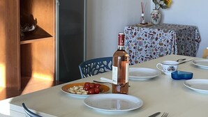 Et spiseområde med et hvidt bord, blå stole og et ur på væggen.