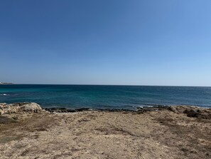 Un paysage côtier caractérisé par un terrain rocheux et une vue dégagée sur la mer.
