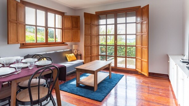 Een eetgedeelte met houten kasten, een tafel en stoelen.