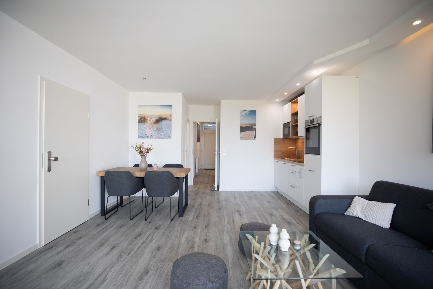 A modern apartment with a dining area, kitchen, and living room.