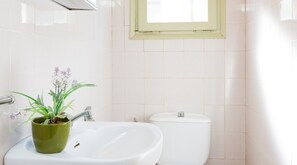 A bathroom with a sink, toilet, and a window above the toilet. - Beach Villa With Private Pool in Llafranc (Palafrugell)