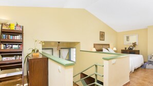 A bedroom with a bed, a nightstand, a lamp, a mirror, a bookshelf, and a window. - Beach Villa With Private Pool in Llafranc (Palafrugell)