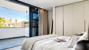 A modern bedroom with a large bed, a balcony, and a view of buildings. - Modern Central Secure Cape Town 2bed Bantry Suite (Cape Town)
