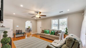 A spacious living room with a sofa, a coffee table, and a ceiling fan. - Walkable Masters Hub! 2 Miles to Augusta National (Augusta)