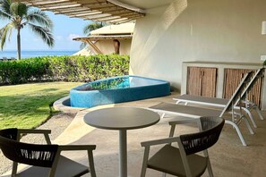 An outdoor seating area with a pool, chairs, and a table.