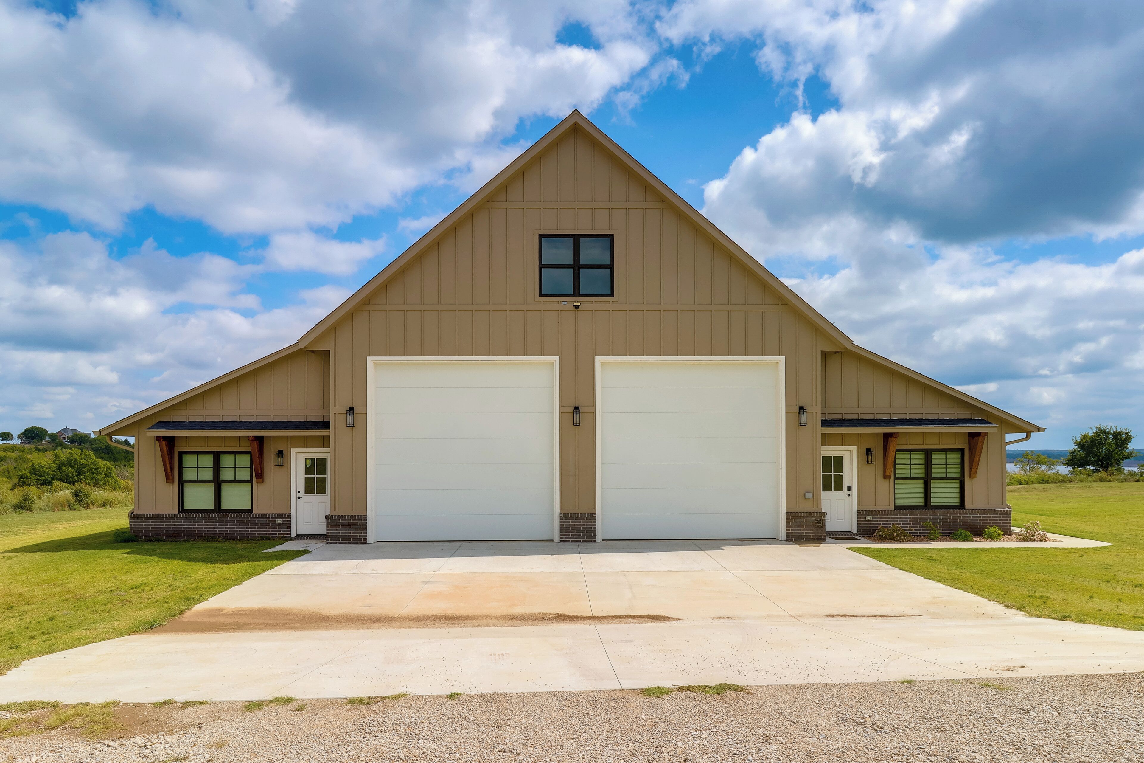 A two-story building with a gabled roof and two garage doors.