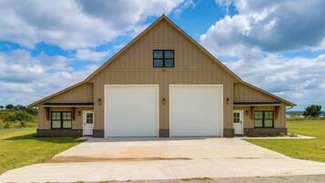 A two-story building with a gabled roof and two garage doors.