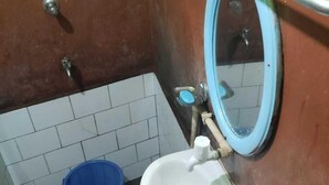 Une petite salle de bain avec un lavabo blanc, un bac bleu et un miroir.