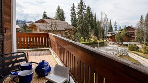 A wooden balcony with a view of a mountain, a wooden fence, and a table with a book, teapot, and cups. - Beautiful apartment for 2 guests with WIFI and balcony (Ollon)