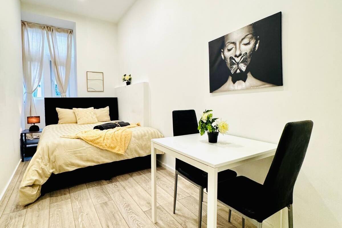 Quarto moderno com cama, mesa de cabeceira e escrivaninha com cadeira.