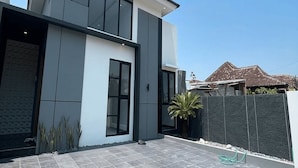 A modern two-story house with a large patio area. - DIRUMA SADJA HOME VILLA (Ngemplak)
