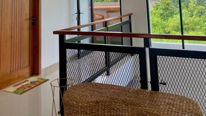 A modern interior with a wooden door, a staircase with a metal railing, and a large window with a view of greenery. - DIRUMA SADJA HOME VILLA (Ngemplak)