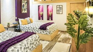 Un dormitorio moderno con dos camas, una mesita pequeña y una planta en maceta.