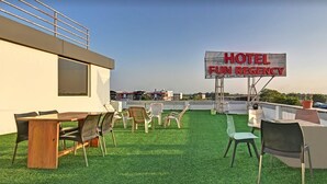 A rooftop terrace with a sign reading "HOTEL FUN REGENCY," featuring outdoor seating and a view of the cityscape. - Hotel Fun Regency (Mandal)