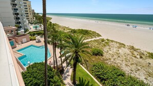 Ein Resort mit Schwimmbad, Blick auf den Strand und Palmen.