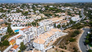 Vista aérea de una zona residencial con edificios blancos, una carretera y un espacio verde.