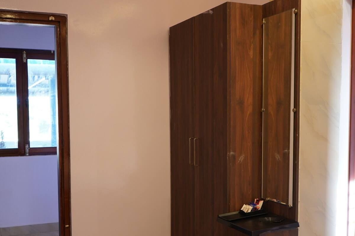 Une chambre à coucher avec un lit, une armoire et une fenêtre.