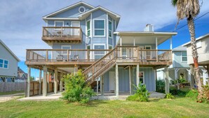 A two-story house with a balcony and a covered porch. - Sleeps 20! 2 Homes Near the Beach, Private Pools, GameRoom, Large Family Retreat (Port Aransas)