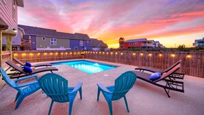 A backyard with a swimming pool, lounge chairs, and a wooden fence. - Sleeps 20! 2 Homes Near the Beach, Private Pools, GameRoom, Large Family Retreat (Port Aransas)