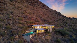A modern house with a pool, surrounded by a rocky landscape. - Panoramic Views, Private Pool, Patio Lounge w/ Firepit | Royal Palm by AvantStay (Paradise Valley)