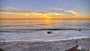 A beach with a sunset, waves, and a few people. - Backyard Oasis w/ Fire Table + Walk to Salt Creek Beach | Dana Point Dreams (Dana Point)