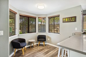 Ein Eckzimmer mit Küchenbereich, einem Esstisch und zwei Stühlen.