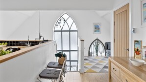 Una cocina moderna con un amplio ventanal, encimera de madera y vistas a la ciudad.