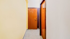 Un pasillo estrecho con una puerta de madera con la etiqueta 'D3' y otra puerta entreabierta a la derecha.