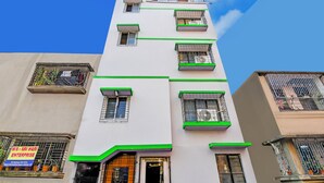 Un edificio de varios pisos con balcones, un letrero que dice M/S Sri Hari Enterprise y un cielo azul despejado.