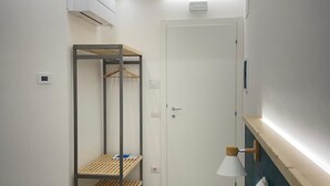 A bedroom with a bunk bed, a bedside table, a lamp, and a wardrobe. - Charming double room in lovely Roma with WiFi, AC (Roma)