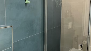 A bathroom with a glass-enclosed shower, a toilet, and a wall-mounted towel rack. - Charming double room in lovely Roma with WiFi, AC (Roma)