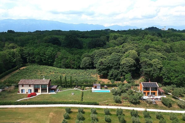 A modern house with a swimming pool, surrounded by lush greenery and mountains in the background. - Villa Montello Pool, Jacuzzi, Ac, Wifi, Treviso (Montebelluna)
