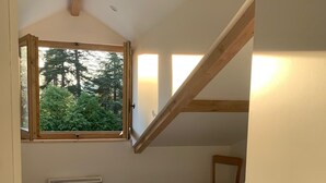 A bedroom with a large window, a radiator, and a wooden chair. - Lovely, warm, fully renovated apartment in the center of the village (Ax-les-Thermes)