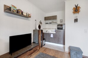 A modern kitchen with grey cabinets, a microwave, and a coffee machine.