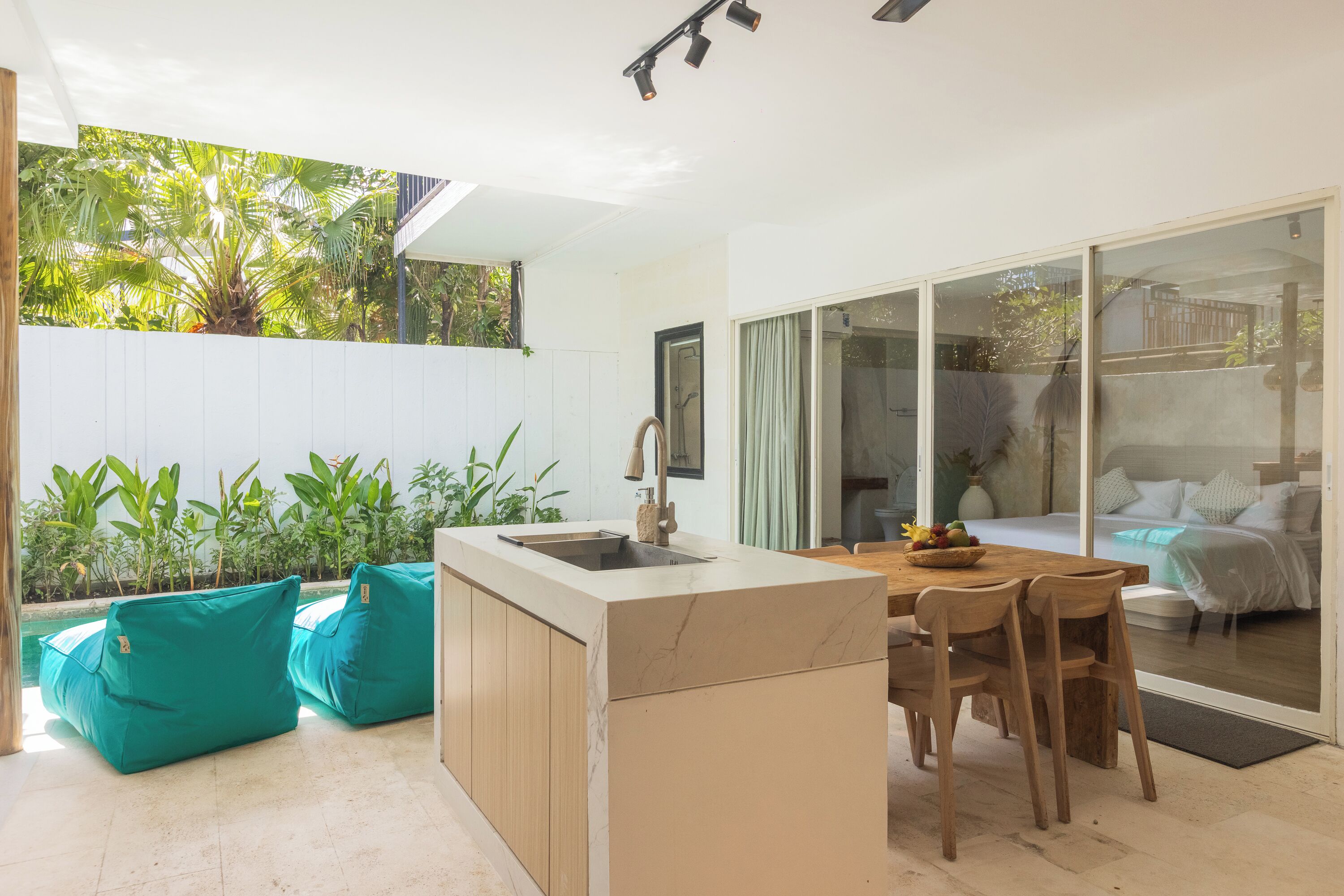Cozinha moderna com bancada de mármore, cadeiras de madeira e mesa de jantar.