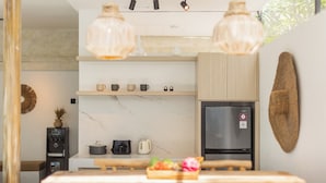 Una cucina moderna con un piano di lavoro in marmo, un frigorifero e un'area pranzo con un tavolo in legno.