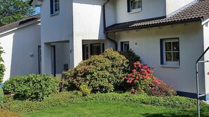 Un bâtiment à deux étages, doté d’une façade blanche, de nombreuses fenêtres et d’un toit recouvert de tuiles.